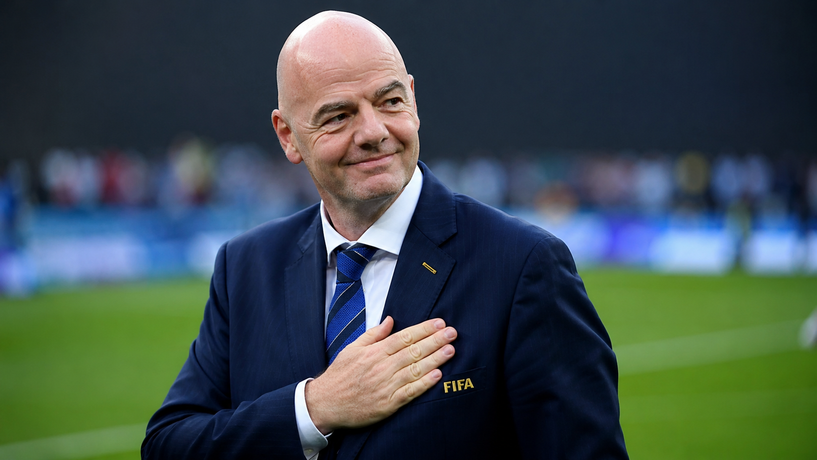 FIFA-præsident Infantino med hånden til hjertet på en fodboldbane